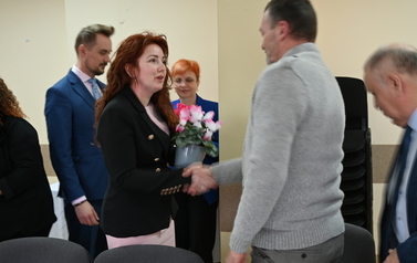widzimy panią przekazującą panu kwiatka doniczkowego