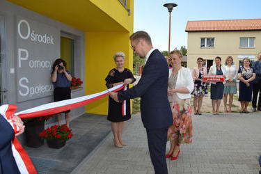 Na zdjęciu w&oacute;jt przecina wstęgę przed drzwiami do budynku