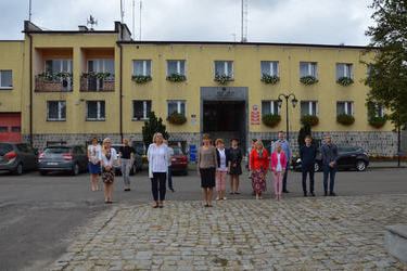 Na zdjęciu widać urzędnik&oacute;w stojących przed pomnikiem na rynku Mieściska