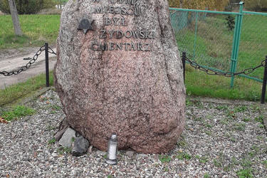 Na zdjęciu znajduje sie duży kamień, kt&oacute;ry symbolizuje cmentarz żydowski  znajdujący się w tym miejscu.