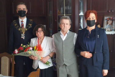 Na zdjęciu od lewej storniy znajduje się mężczyzna w granatowym garniturze - w&oacute;jt Gminy, obok starsze małżeństwo, następnie kobieta w grantowej sukience, rudych kr&oacute;tkich włosach-kierownik Urzędu Stanu Cywilnego