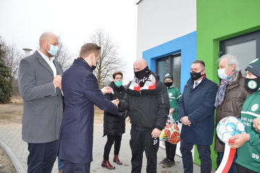 Na zdjęciu w&oacute;jt wręcza klucz do szatni prezesowi klubu Patriot - mężczyzna ubrany w czarny dres z szalikiem klubu.