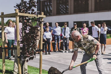 Na zdjęciu widać właściciela firmy Serpol-Cosmetiocs sadzącego drzewko przed siedzibą firmy.