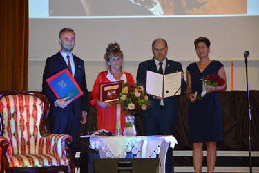 Od lewej strony stoi w&oacute;jt Gminy Mieścisko, pani Czesia z kwiatami i odznaczeniem, starosta z dyplomem oraz pani przewodnicząca Rady Gminy Mieścisko