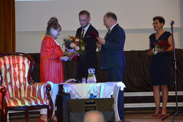 W&oacute;jt Gminy Mieścisko wraz z  starostą wręczaja pani Czesi kwiaty oraz odznaczenia