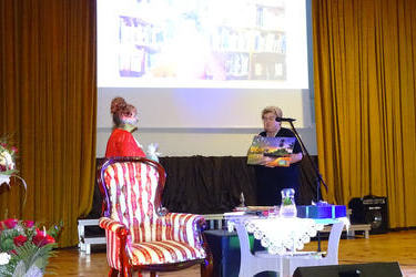 Kobieta w czarnej sukni wręcza prezent pani Czesi