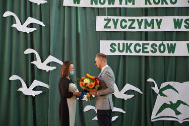 Na zdjęciu widać Pana W&oacute;jta wręczjącego nominację nowej Pani Dyrektor Szkoły Podstawowej. Ubrani są odświętnie Pan &oacute;jt trzyma w ręcach bukiet kwiat&oacute;w
