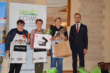 Na zdjęciu widać w&oacute;jta ze zwycięskim KGW z Podlesia Wysokiego. Trzy kobiety trzymają puchar i nagrody.