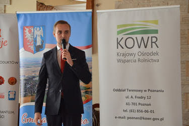 Na zdjęciu widać przemawiającego pana W&oacute;jta. Ubrany jest w jasną koszulę, czerwony krawat i granatowy garnitur.