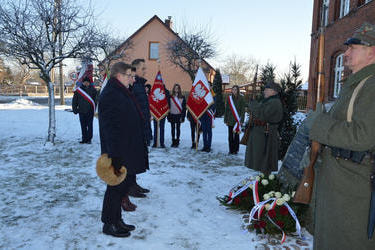 Na zdjęciu widać w&oacute;jta gminy, przewodniczącą rady oraz radnego powiatu składających wiązanki przed pomnikiem powstańc&oacute;w wielkopolskich