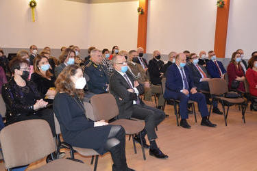 Na zdjęciu widać siedzących gości. Wpatrzeni są w przemawiającego w&oacute;jta.