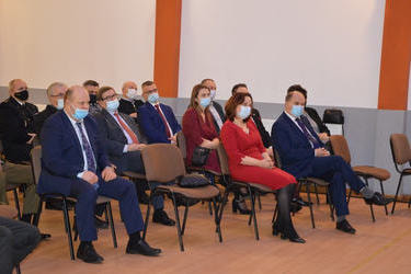 Na zdjęciu widać siedzących gości. Wpatrzeni są w przemawiającego w&oacute;jta.
