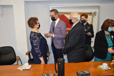 Na zdjęciu w&oacute;jt dekoruje jubilat&oacute;w orderami. Starsza kobieta w kr&oacute;tkich włosach, ma na sobie granatową sukienkę. Mężczyzna w czarnym garniturze. 