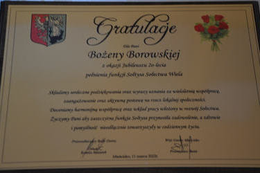 Zdjęcie grawertonu z gratulacjami dla pani Bożeny Borowskiej z okazji 20lecia bycia sołtysem.