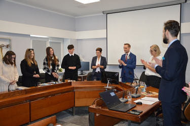 Na zdjęciu wszyscy klaszczą, są uśmiechnięci.