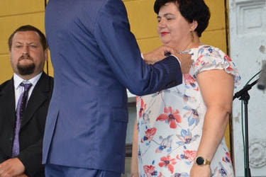 Na zdjęciu widac jak w&oacute;jt odznacza starościnę dożynek odznaką Herbu Gminy