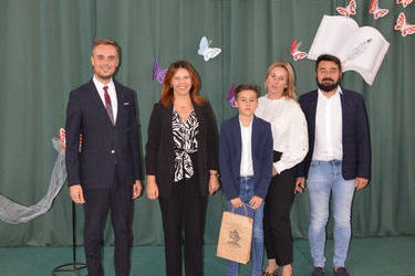 Na zdjęciu od lewej strony stoi w&oacute;jt, obok dyrekotr szkoły w popowie, następnie stypendysta w granatowym garniturze, obok niego mama i tata w eleganckich strojach.