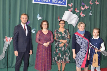 Zdjęcie przedstawia od lewej strony w&oacute;jta, panią dyrektor w okularach i śliwkowej sukni, następnie radna w kwiecistej sukience, obok stypendystka w granatowej sukience, a obok niej mama we wzorzystej sukni.