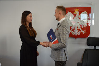 Na zdjęciu w&oacute;jt wręcza nagrodę nauczycielce. Kobieta ma długie ciemne włosy, ubrana jest w czarną sukienkę.