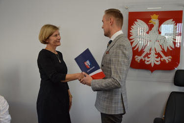 Na zdjęciu w&oacute;jt wręcza nagrodę nauczycielce. Kobietas ma jasne włosy do uszu, ubrana jest w czarną sukienkę.
