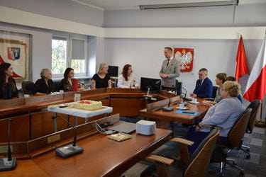 Zdjęcie przedstawia zgromadzonych nauczycieli na sali sesyjnej. W centralnym miejscu stoi w&oacute;jt i przemawia. Nauczyciele i zaproszeni goście siedzą wok&oacute;ł stołu sesyjnego.