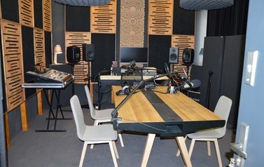 Zdjęcie przedstawia nowoczesne studio nagrań.