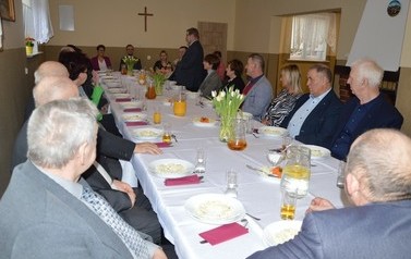 Na zdjęciu widać zgromadzonych siedzących przy stole.