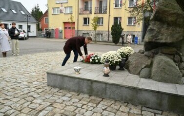 burmistrz składa wiązankę na pomniku
