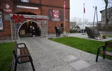 widzimy pana m&oacute;wiącego do mikrofonu oraz kilka os&oacute;b stojących obok niego 