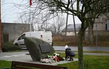 widzimy dziewczynkę kucającą przed pomnikiem