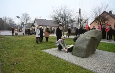 widzimy dwie panie kładące znicz pod pomnik