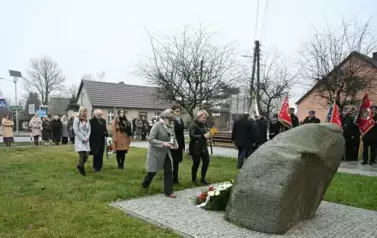widzimy dwie panie kładące znicz pod pomnik