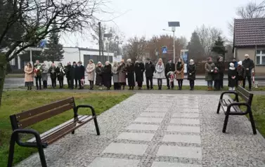 widzimy dużą liczbę os&oacute;b oraz kilka os&oacute;b z kwiatami w dłoniach