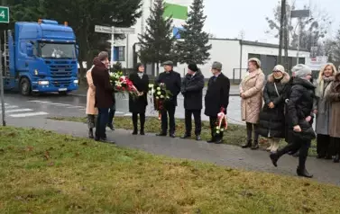 widzimy kilka os&oacute;b z kwiatami w dłoniach