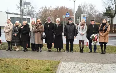 widzimy kilka os&oacute;b stojących przed pomnikiem