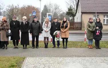 widzimy kilka os&oacute;b stojących przed pomnikiem