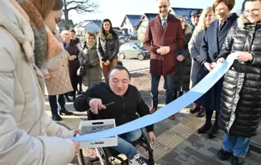 widzimy pana na w&oacute;zku inwalidzkim trzymającego nożyczki w dłoni