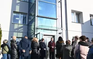 widzimy liczną grupę os&oacute;b stojącą przed windą