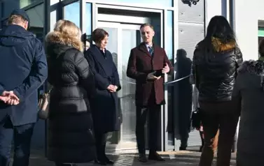 widzimy liczną grupę os&oacute;b stojącą przed windą