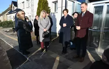 widzimy kilka os&oacute;b stojących przed windą