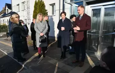 widzimy kilka os&oacute;b stojących przed windą