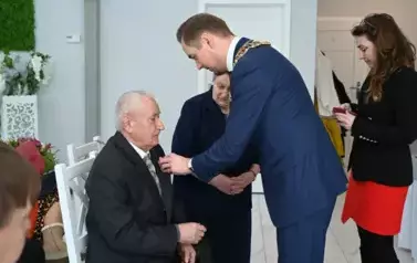 burmistrz przypina medal Jubilatom