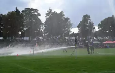 Zdjęcie przedstawia podanie prąd&oacute;w wody przez strażak&oacute;w w celu trafienia w tarcze i strącenie pachołk&oacute;w by ukończyć konkurencję