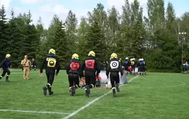 Strażacy biegną do zadania konkurencyjnego rozwinięcia linii ssawnej od zbiornika wodnego do motopompy