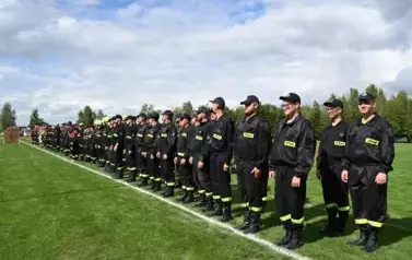 Drużyny strażackie stoją w jednej lini na baczność