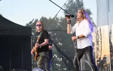 widzimy śpiewającego wokalistę oraz pana grającego na gitarze