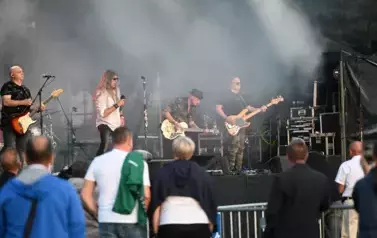 widzimy wokalistę oraz trzech pan&oacute;w grających na gitarze 