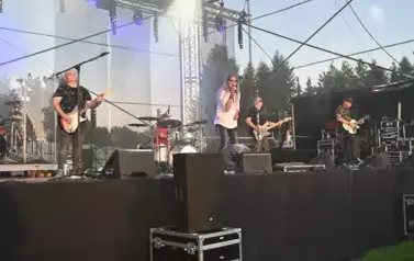 widzimy wokalistę, trzech pan&oacute;w grających na gitarze oraz pana grającego na perkusji