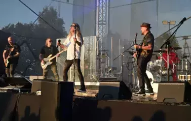 widzimy wokalistę, trzech pan&oacute;w grających na gitarze oraz pana grającego na  perkusji