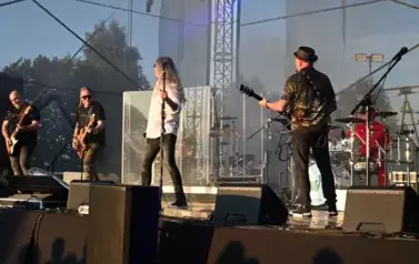 widzimy wokalistę oraz trzech pan&oacute;w grających na gitarze 